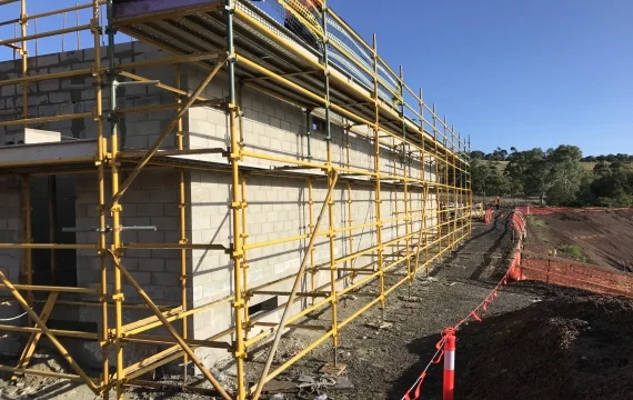 New Building Construction With Yellow Scaffolding - Multiworks